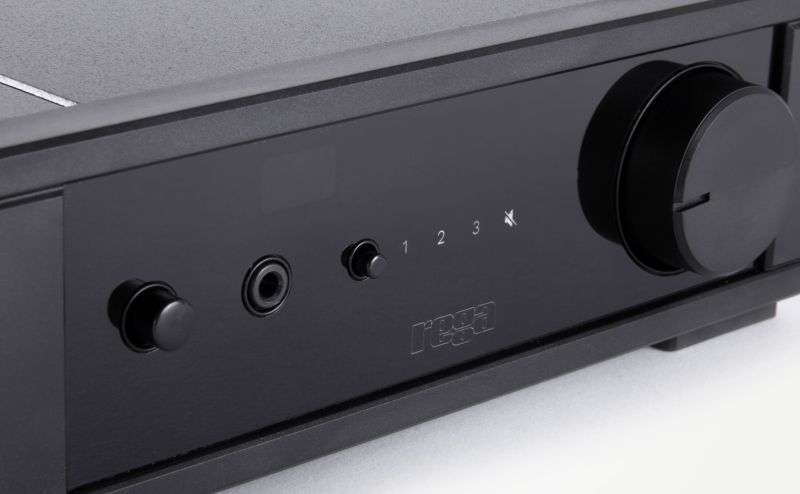 Close-up of the io fascia: power button, headphone socket, source selector, the 1-2-3 input markers, mute symbol and the large volume knob