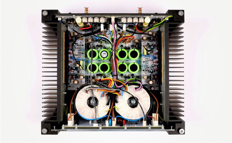 The Solis seen from directly above with the lid off: two toroidal transformers, the green K-Power reservoir capacitors and both heatsink walls