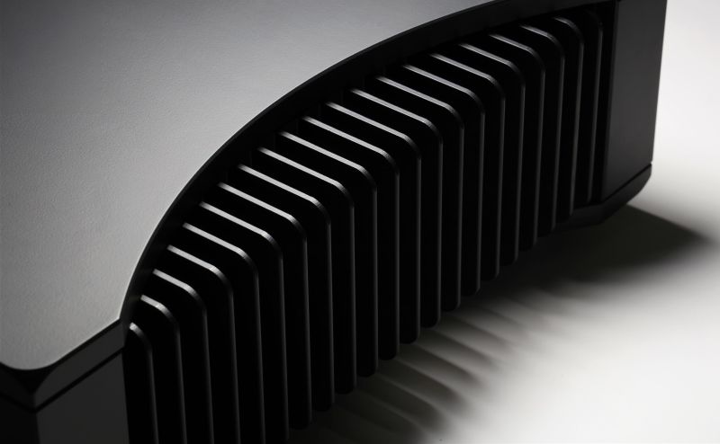 Macro of the Solis flank where the polished curved top meets the black heatsink, the fins running away into shadow