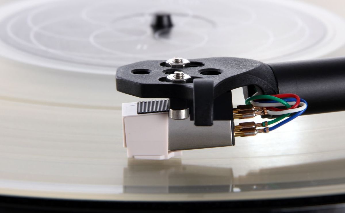 The Carbon seen from behind on the arm, the four colour-coded tag wires and the drilled headshell above a spinning record