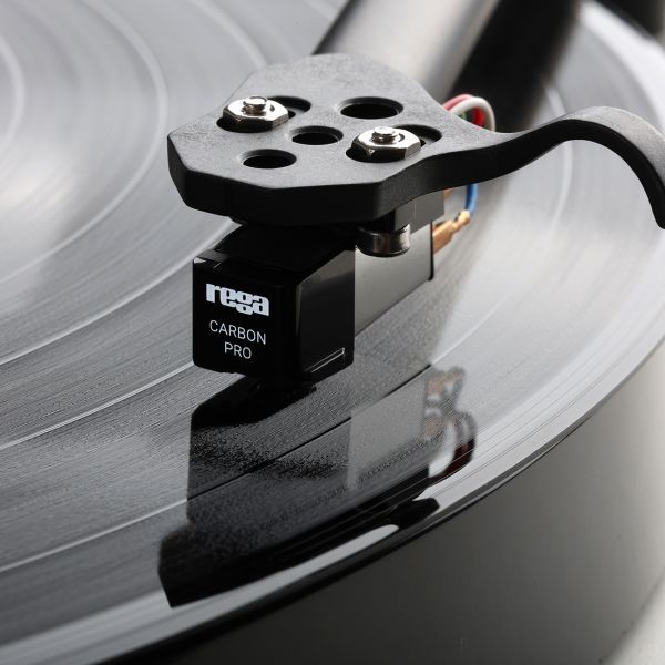 The Carbon Pro stylus fitted to a cartridge on a Rega arm above a record, the housing lettered rega CARBON PRO