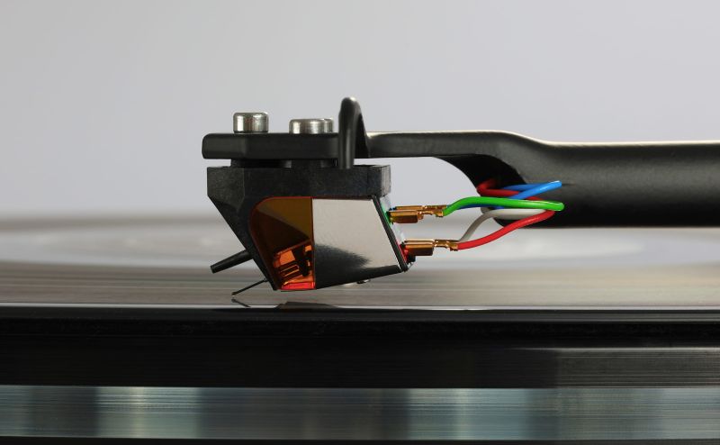 The Nd9 in profile on the tonearm, stylus down on the record surface, headshell bolts and tag wires in view