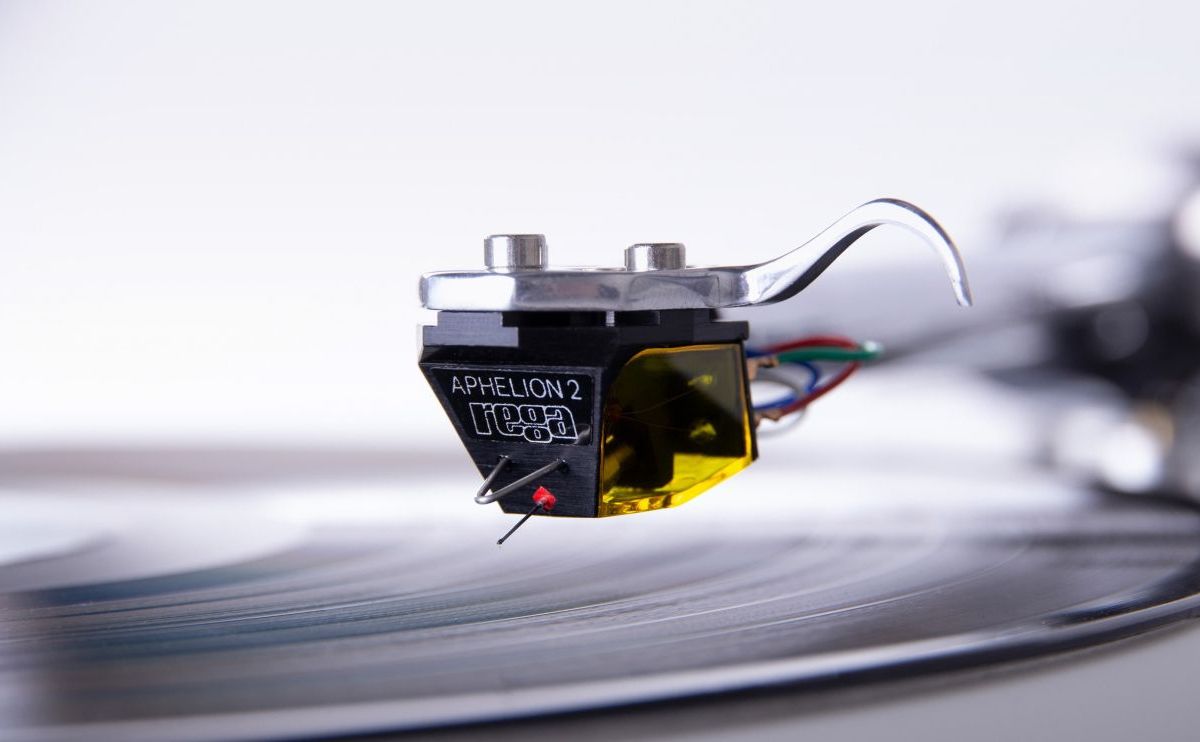 The Aphelion 2 tracking a record, the flank lettered APHELION 2 and the rega logo, grooves and spindle behind