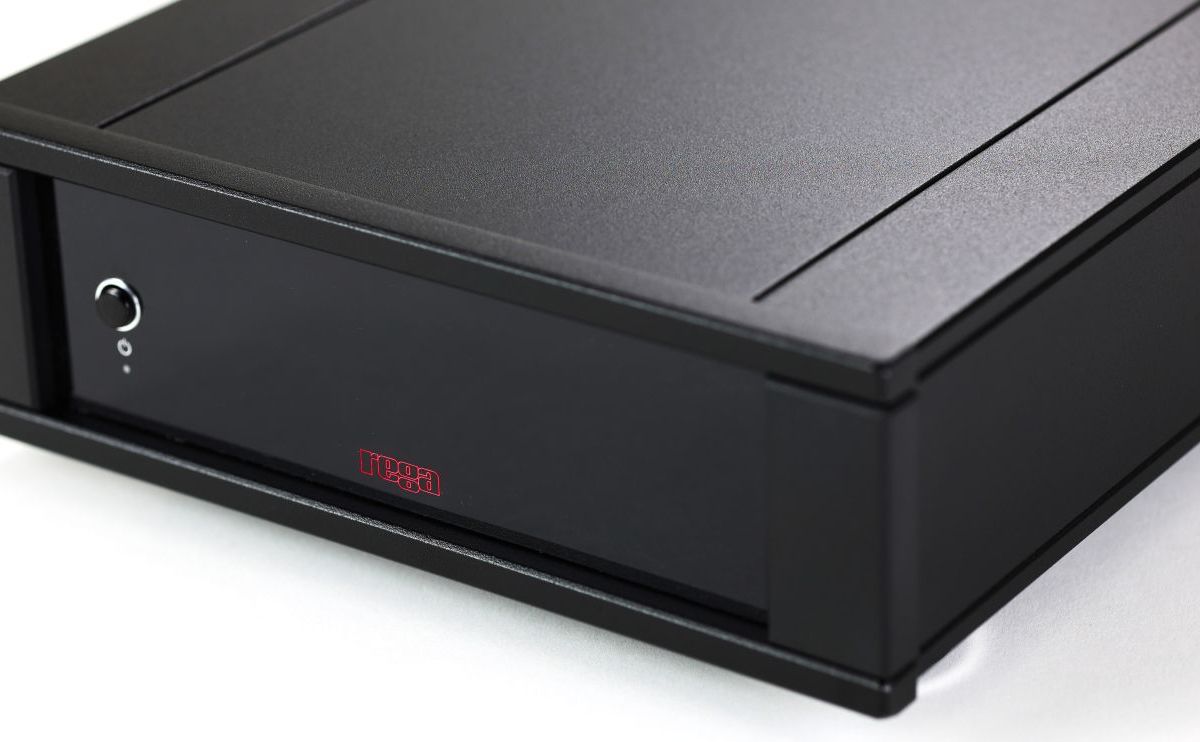 Close view of the Aos MC top plate and front edge, showing the stepped aluminium casework and the recessed button