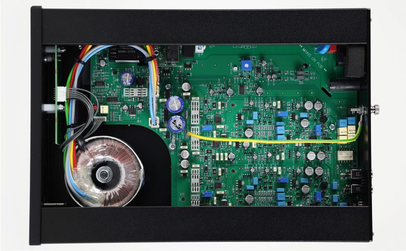 The Aos MC with its lid removed, seen from above: the green circuit board, the toroidal transformer and the coloured internal wiring
