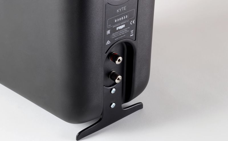 Close-up of the Kyte's two binding posts and the black steel rear foot bolted under the phenolic cabinet