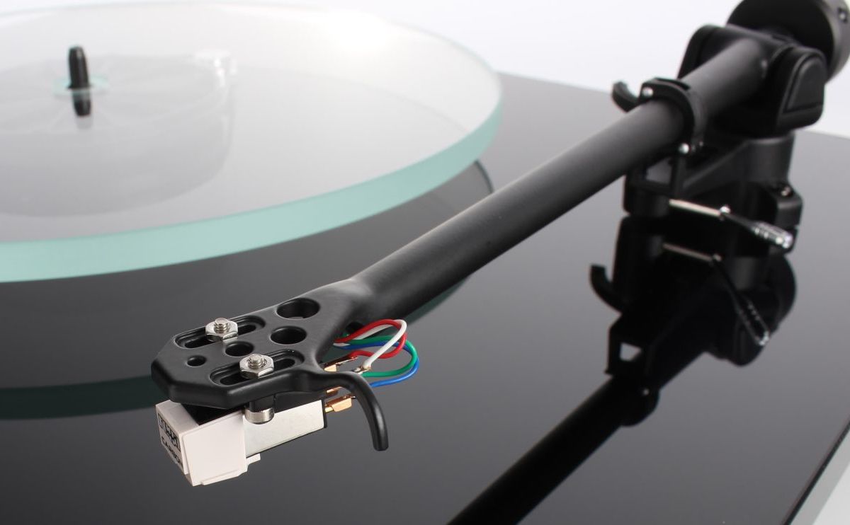 The RB220 headshell and cartridge tag wires above a glass platter