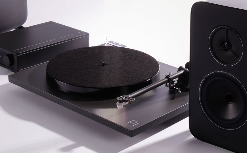 Close side view of the System One, the Planar 1 platter and felt mat with the RB110 arm, the io amplifier behind it and one Kyte loudspeaker at right