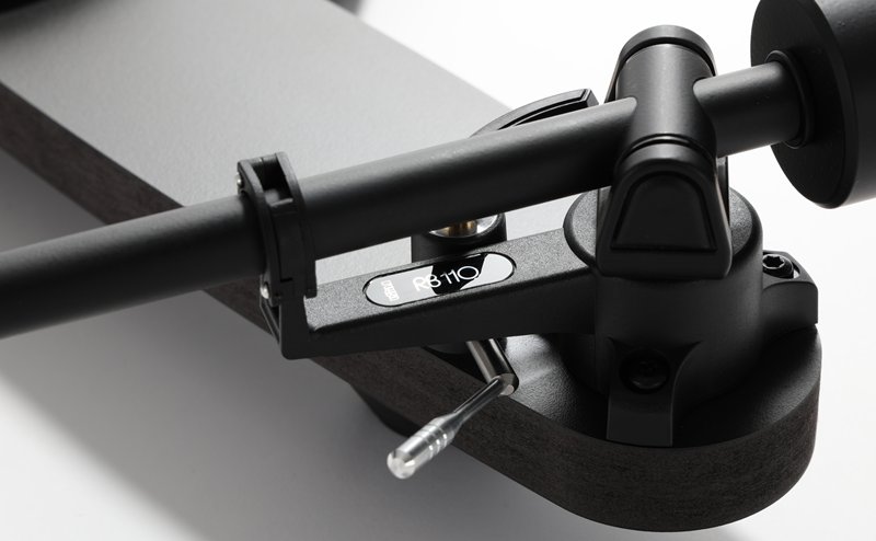 Close-up of the RB110 tonearm on the Rega Replay: the bearing housing, arm lift and counterweight in matt black.