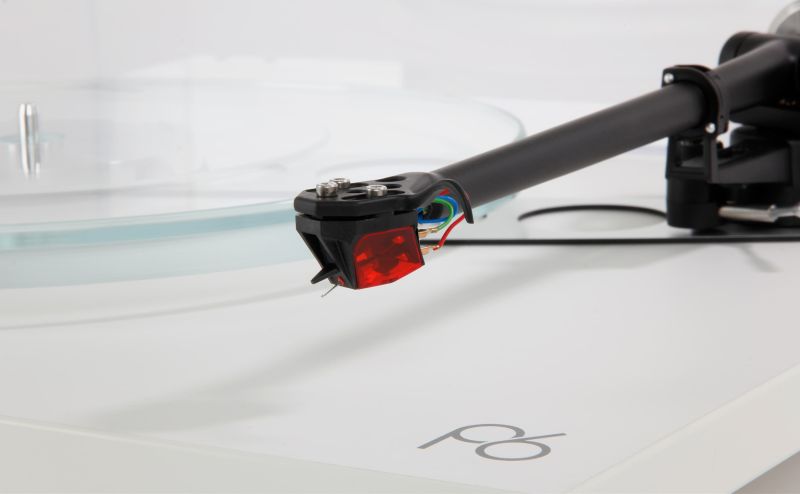 The cartridge tracking above the glass platter on the matt white Planar 6